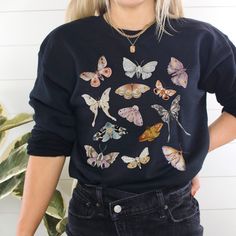 Introducing the Moth Sweatshirt, a captivating fusion of granola girl, fairy core and goblincore fashion. This biology-inspired shirt features a stunning Moth design, blending nature and fantasy seamlessly. With its cozy fit and witchy warmth, this enchanting garment is perfect for those who love to embrace the magical realms and express their unique style. Embody the allure of Moths and immerse yourself in the mystical world of goblincore with the Moth Sweater. **Size UP for Oversized Look** Th Fairy Grunge Cotton Tops With Crew Neck, Fairy Grunge Long Sleeve Graphic Top, Fairy Grunge Long Sleeve Top For Fall, Fairy Grunge Cotton Top For Festivals, Fall Goblincore Tops With Graphic Print, Fall Fairy Grunge Cotton Tops, Goblincore Long Sleeve Tops For Fall, Fall Graphic Print Goblincore Tops, Fairy Grunge Cotton Tops For Fall