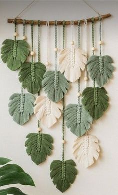 a green and white wall hanging with leaves