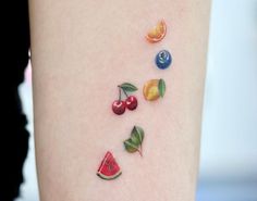 a woman's thigh with fruit tattoos on it