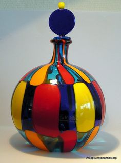 a multicolored glass vase sitting on top of a table