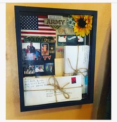 an army bulletin board with pictures, mail and sunflowers on the wall next to it