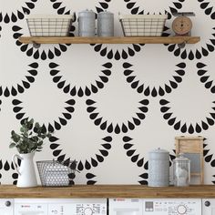 a laundry room with black and white wallpaper that has circular shapes on the walls