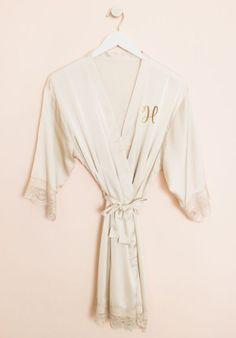 Mrs. Satin Robes Monogram satin lace robes are an ideal gift for bridesmaids, the bride to be or even as a birthday gift! These delicate robes come in the color of your choice and are made of soft polyester satin. Each robe comes personalized with a gold foil monogram of your choice and with a matching belt for the outside and a delicate lace trim. NO RETURNS OR EXCHANGES ON SHIRTS/CLOTHING ITEMS. Fabric: Soft Polyester Satin CARE INSTRUCTIONS: Delicate cycle wash, hang dry, do not bleach - iron Luxury Elegant Robe With Satin Trim, Cream Satin Robe For Wedding Night, Luxury Satin Finish Robe For Women, Satin Robe With Lace Trim And Long Sleeves, Luxury Satin Robe With Lace Trim, Elegant Satin Sleep Robe, Monogram Robes, Polyester Satin, Gift Boutique