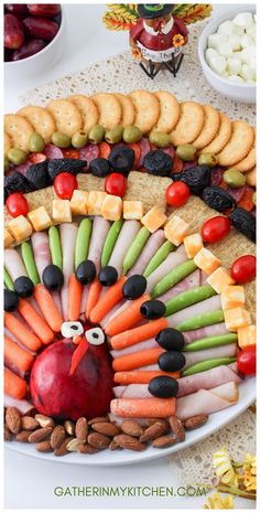 a turkey made out of crackers and vegetables on a platter with other snacks