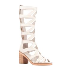 Discover the Loni, a contemporary take on the classic gladiator sandal. Crafted from supple genuine leather, its knee high upper and stacked heel redefine sophistication with a touch of boldness. Perfect for those who appreciate distinctive style, the Loni combines comfort with statement making design. Whether paired with skirts, dresses or cropped pants, this sandal promises to elevate your look with its unique blend of craftsmanship and flair, ensuring you stand out in any setting. Low Block Heel Sandal, Gladiator Flats, Flat Gladiator Sandals, Cold Shoulder Shirt, White Sandals Heels, Trending Sandals, Footbed Sandals, Open Toe Shoes, Low Block Heels