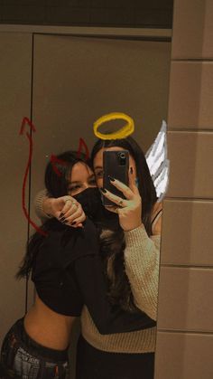 two women are taking a selfie in front of a mirror with their arms around each other