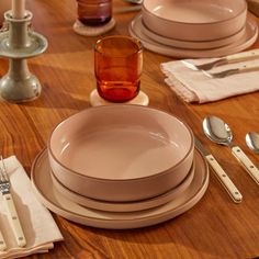 a wooden table topped with plates and silverware