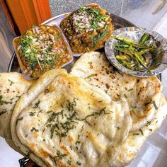 several different types of food on a silver plate with sauces and seasoning next to each other