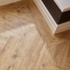 an empty room with wood flooring and white trim