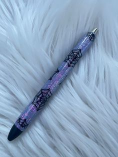 a purple pen sitting on top of a white fur covered floor next to a black object