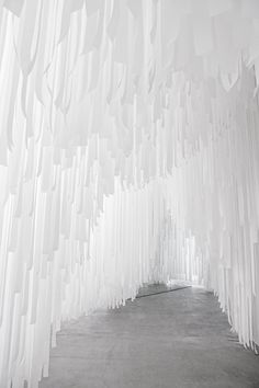 an abstract white sculpture is shown in this black and white photo, it looks like icicles are hanging from the ceiling