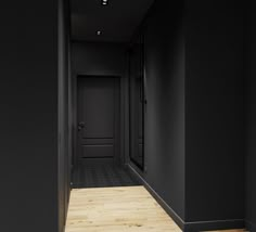 an empty hallway with black walls and wooden floors