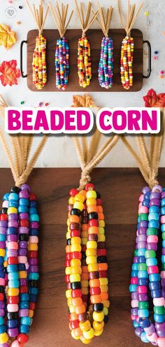 colorful beaded corn hanging from hooks on a wooden table with text overlay reading beaded corn