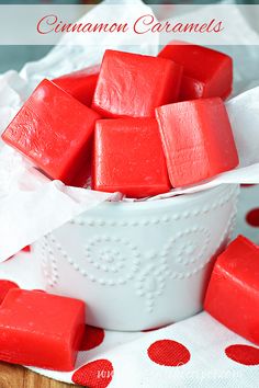 a white bowl filled with red candy on top of a table