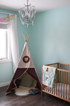 a child's room with a teepee tent and crib