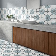 a bathroom with white and blue tiles on the walls, counter top and sink area