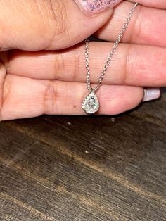 a woman's hand holding a diamond necklace