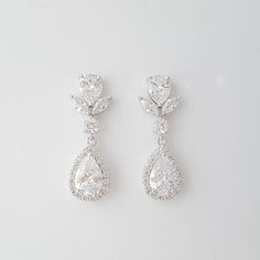 Crystal bridal earrings made with glittering halo set teardrop cubic zirconia crystals put onto cz detailed ear posts. The wedding earrings are also available in rose gold finish and 14k gold finish. Material used is rhodium plated brass components. Earrings are light weight and a great length. # length of Earring from top is approx. - 1 2/8 inches or 3.2 cms and 10 mm wide Please see link below for matching pieces. Emma Collection https://www.etsy.com/au/shop/poetryjewelry?ref=listing-shop-head Wedding Halo Setting Dangle Earrings, Wedding Dangle Earrings With Halo Setting, Sparkling Diamond White Teardrop Bridal Earrings, Wedding Halo Setting Dangle Diamond Earrings, Bridal Halo Design Cubic Zirconia Drop Earrings, Pear-shaped Diamond Earrings With Halo Setting For Wedding, Halo Design Cubic Zirconia Bridal Drop Earrings, Sparkling Cubic Zirconia Teardrop Earrings For Wedding, Wedding Earrings With Sparkling Teardrop Pendants