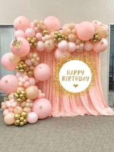 pink and gold balloon arch with happy birthday sign