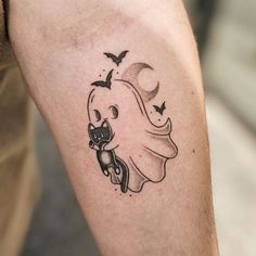 a man's arm with a tattoo on it that has a ghost holding a bat