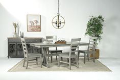 a dining room table with chairs and a potted plant