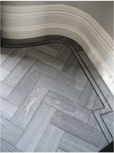 the corner of a room that has a herringbone pattern on it