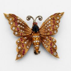 "Vintage 18 K (.750) yellow gold brooch in form of a butterfly with moving hinged wings and enamel on the body. It is richly decorated with Rubies, Diamonds and Sapphires; The Diamonds are single and rose cut. This stunning brooch is 1 7/8\" long, 2 1/4\" wide and weighs 22.2 grams. EA1079" Luxury Gold Enamel Brooch, Luxury Gold Enamel Brooches, Elegant Butterfly Brooch For Collectors, Elegant Collectible Butterfly Brooches, Elegant Butterfly Brooches For Collectors, Elegant Butterfly Brooch, Gold Butterfly Brooches For Collectors, Luxury Butterfly Brooch As Gift, Luxury Butterfly Brooches For Gifts