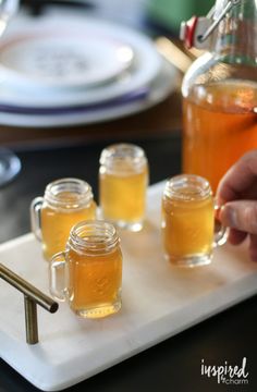 three jars of honey sit on a white tray