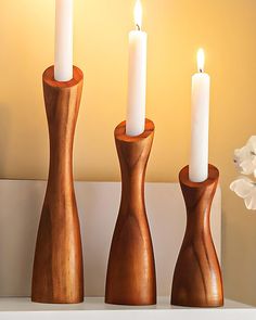 three wooden candlesticks sitting on top of a shelf