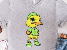 "Take the support of your child's softball team to a whole new level with this Issaquah Ducks Tee Shirt!  Featuring an originally designed iconic Issaquah Ducks logo across the chest, this shirt is a bold statement piece that's sure to turn heads. The Back features the \"Issaquah Ducks\" text in the team's colors of Yellow and Lime Green.  Whether you're cheering on the team from the stands, hitting the gym, or just lounging around at home, this Issaquah Ducks shirt is the perfect choice. Join t Fan Apparel Tops With Mascot For Sports Events, Casual T-shirt With Mascot For Fan Gear, Sporty Mascot Top For Fan Gear, Casual Fan Gear T-shirt With Mascot, Sporty Tops With Mascot For Fan Gear, Cotton Mascot T-shirt For Sports Events, Casual Mascot T-shirt For Fans, Mascot Cotton T-shirt For Sports Events, Cotton T-shirt With Mascot For Sports Events