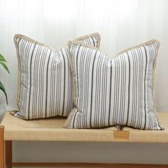 two pillows sitting on top of a wooden bench