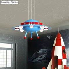 a red and white rocket ship lamp hanging from the ceiling in a child's room