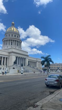 a car parked in front of a building with a golden dome on it's roof