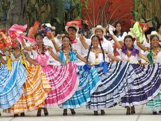 a group of people that are standing in the street with some kind of colorful dress