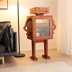 a wooden robot standing next to a couch in front of a lamp and rug on the floor