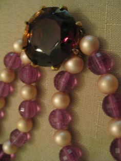 a necklace with pearls and a large stone