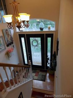 an overhead view of a staircase leading to a front door with glass panels and wrought iron railing