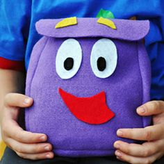 a little boy holding a purple backpack with eyes