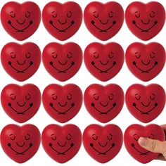 a hand is holding a red heart shaped magnets with faces drawn on it and smiling