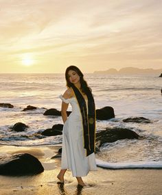 a woman standing on top of a beach next to the ocean