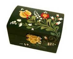 a green box with floral designs painted on the side and gold trimming around it