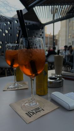 two glasses filled with liquid sitting on top of a table