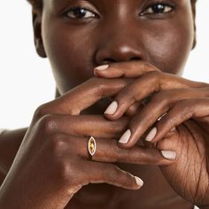 a close up of a person with a ring on their finger and her hand in front of her face