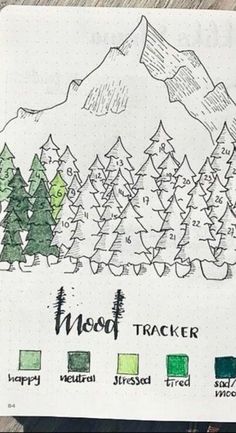 an open notebook with trees and mountains drawn on it