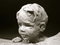 a clay sculpture of a man's head with hair