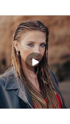 a woman with long hair and blue eyes wearing a black jacket is looking at the camera