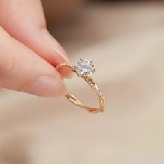 a person holding a diamond ring in their hand