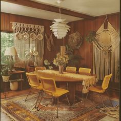 a dining room table with yellow chairs and rugs in front of the window,