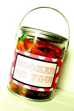 a jar filled with gummy bears sitting on top of a counter next to a white wall