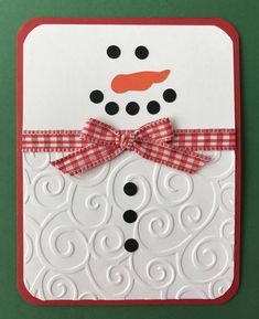 a close up of a card with a snowman on it's face and red ribbon